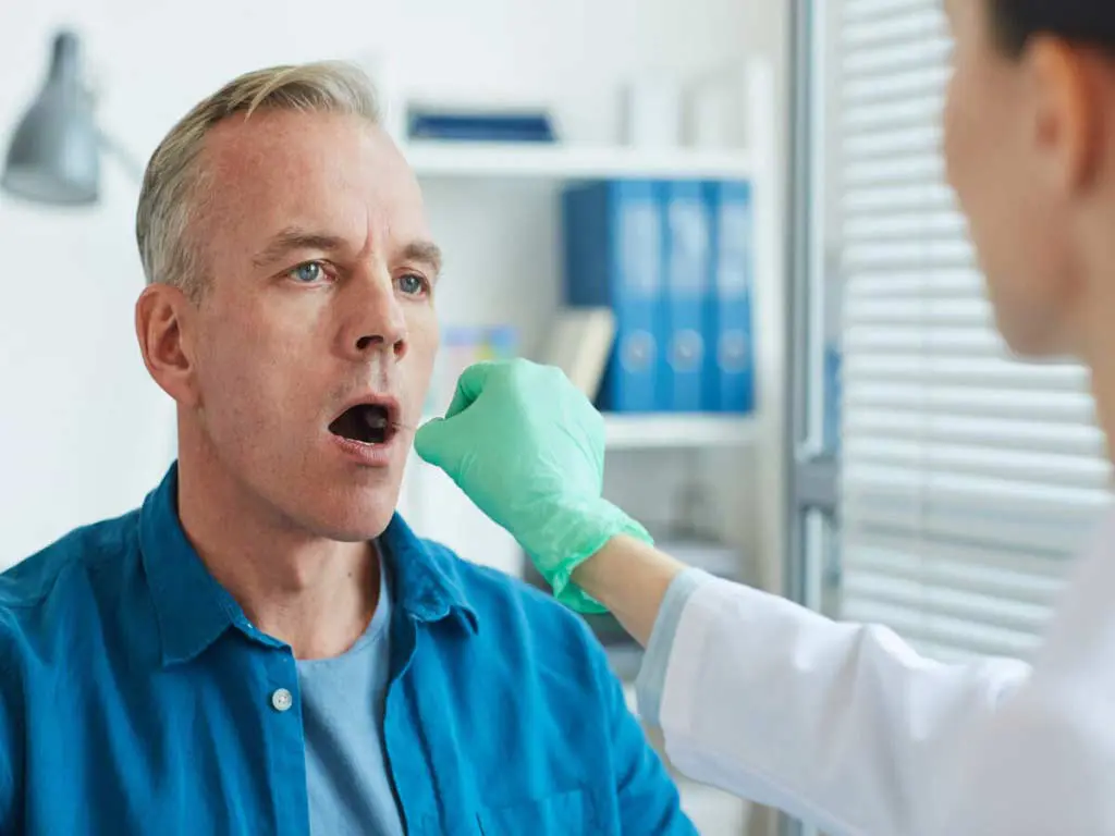 A professional conducting a swab test on male individual