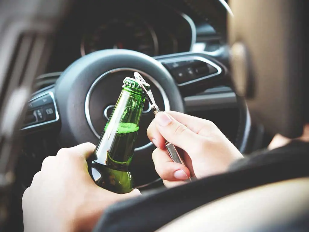 alcohol drug testing what drivers need to know 1 A person driving while opening a bottle of alcohol