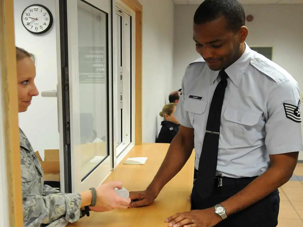 An aviation staff handing a specimen container to an officer