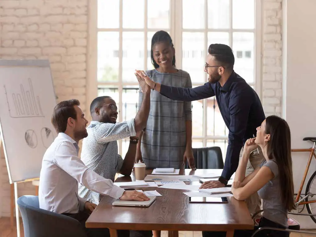 Five employees working happily in a workplace