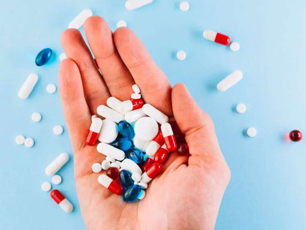 A person holding different types of drug using one hand