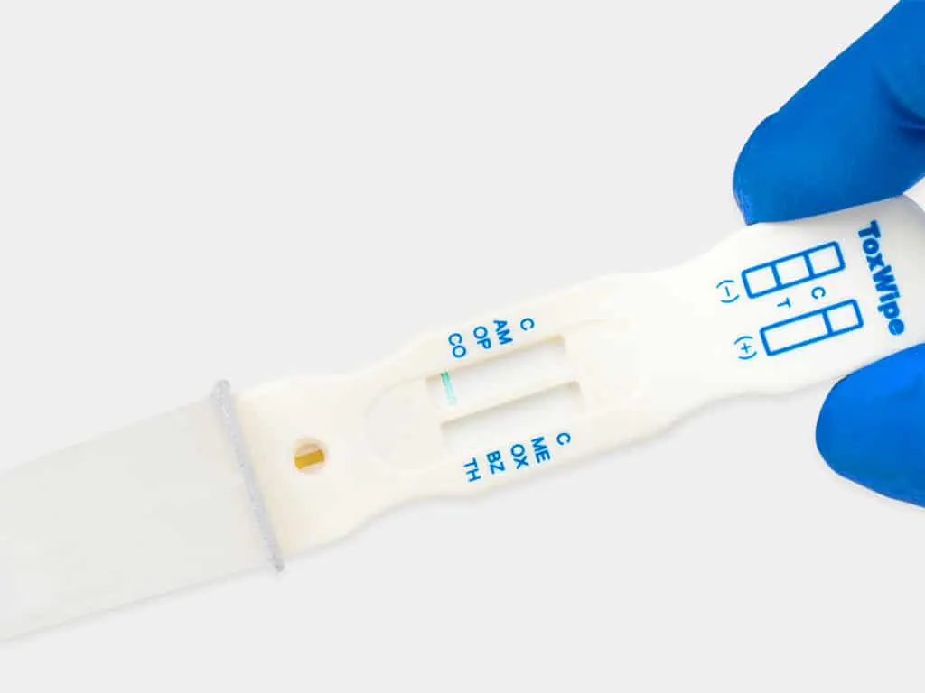 A hand holding the ToxWipe 7 saliva drug test kit