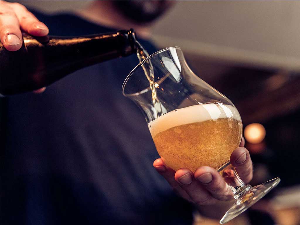 A person pouring alcohol in a glass