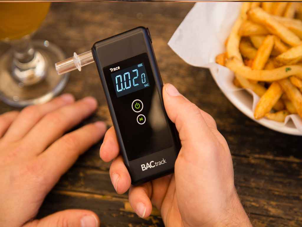 A person holding a breathalyser