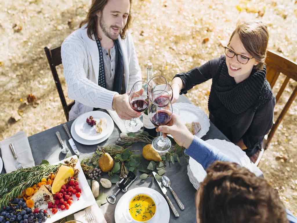 A gathering of individuals enjoying food and beverages outdoors