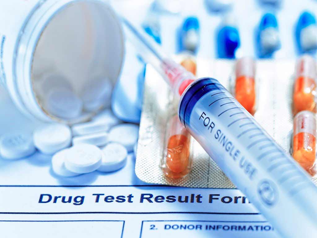 A drug test result form with a variety of drugs and a syringe on top
