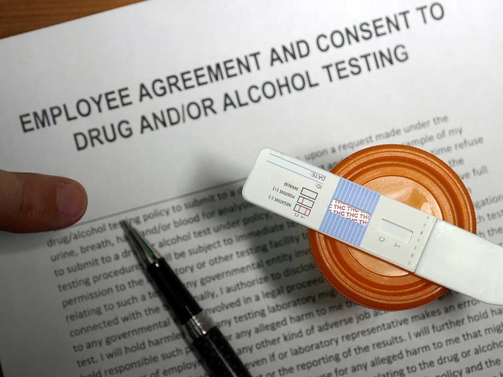Employee agreement and consent form and drug test kits on the table