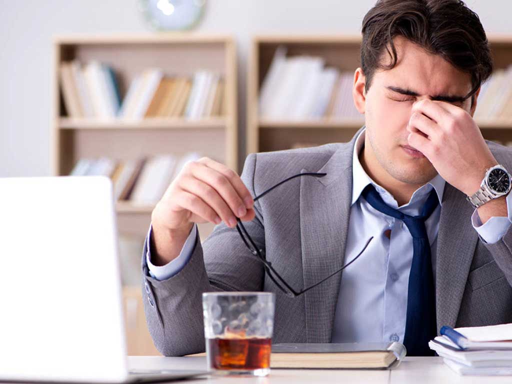 Man with headache behind a desk