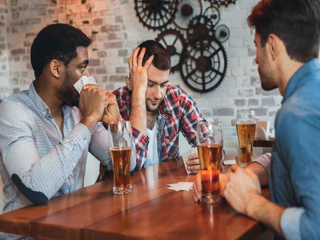 A man having a headache while drinking