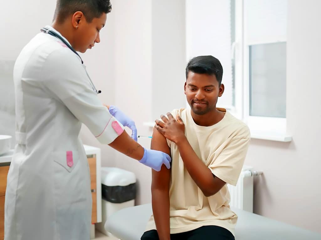 A medical professional drawing a blood sample from a male patient