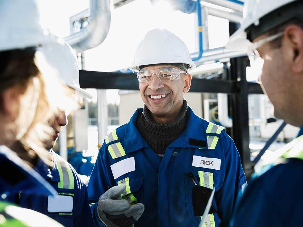 Four workers working in a safe environment while wearing hard hats