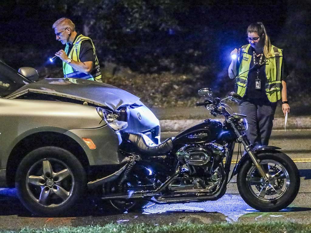 A car that crashed into a motorcycle and two police officers inspecting