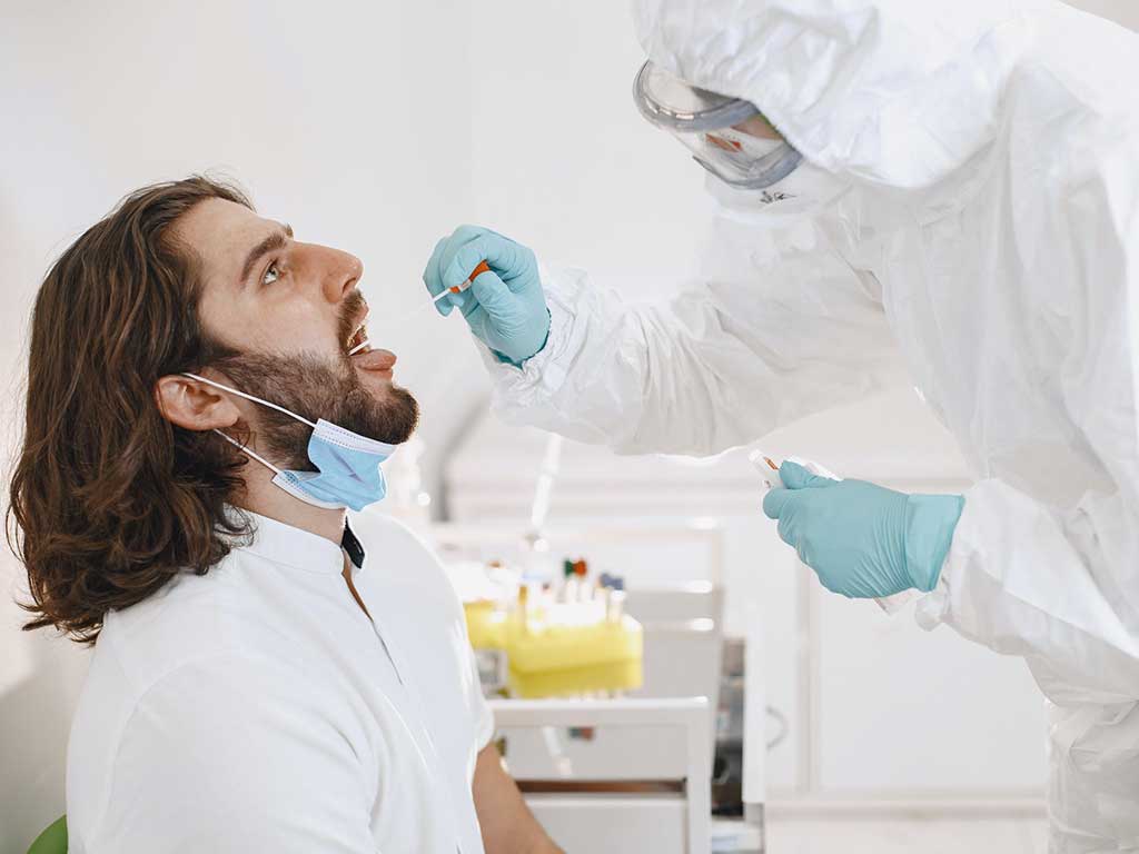 A medical professional conducting a mouth swab test