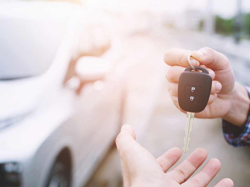 A person giving their car keys to someone else