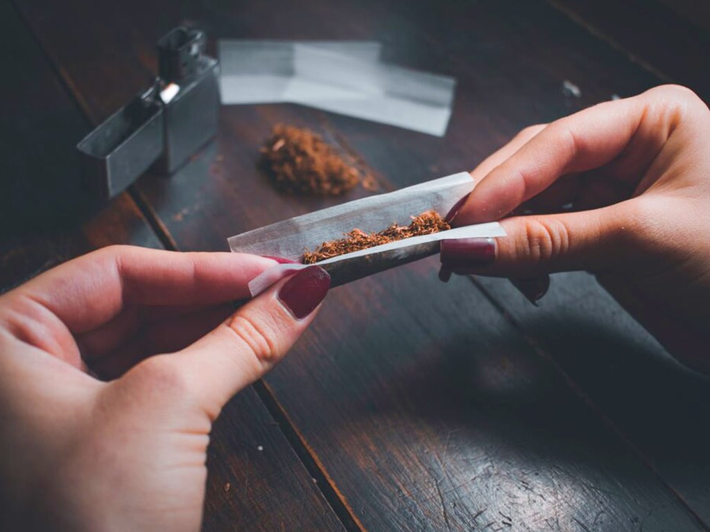 how long does marijuana stay in your saliva. 1 1 2 A person rolling up a paper with drugs