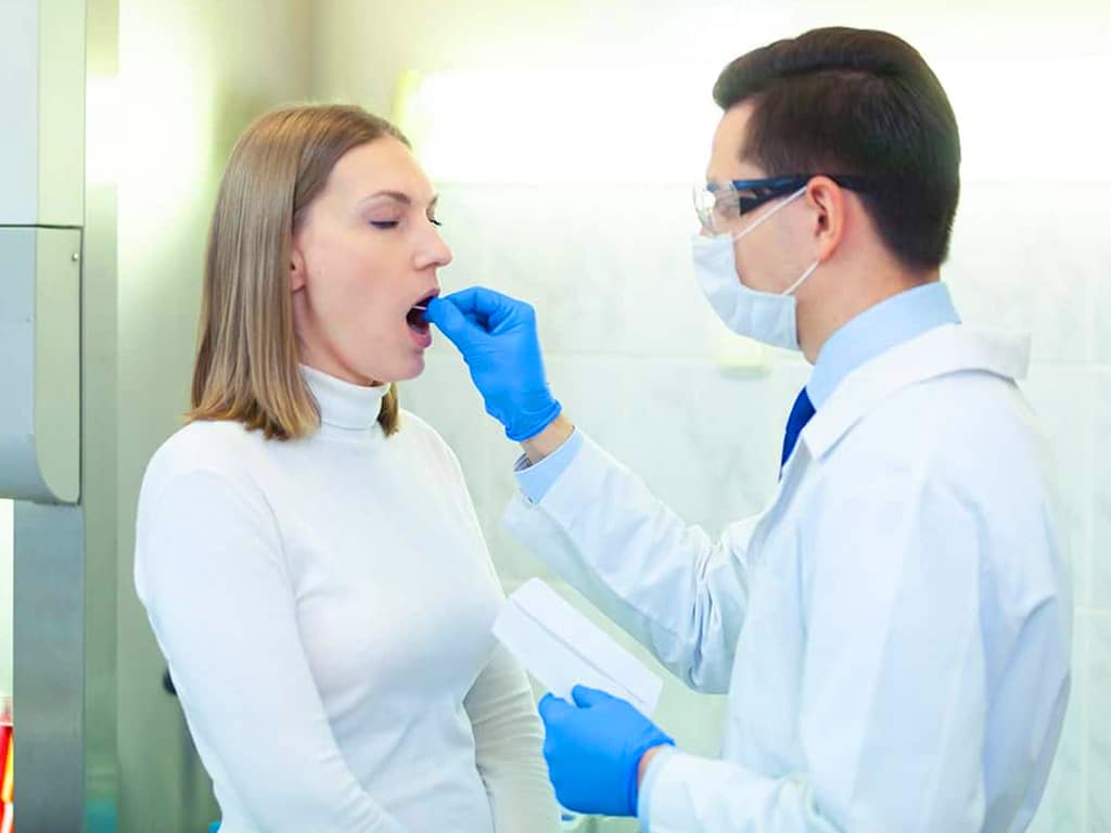 random drug testing. 2 A professional collecting saliva samples from a female candidate
