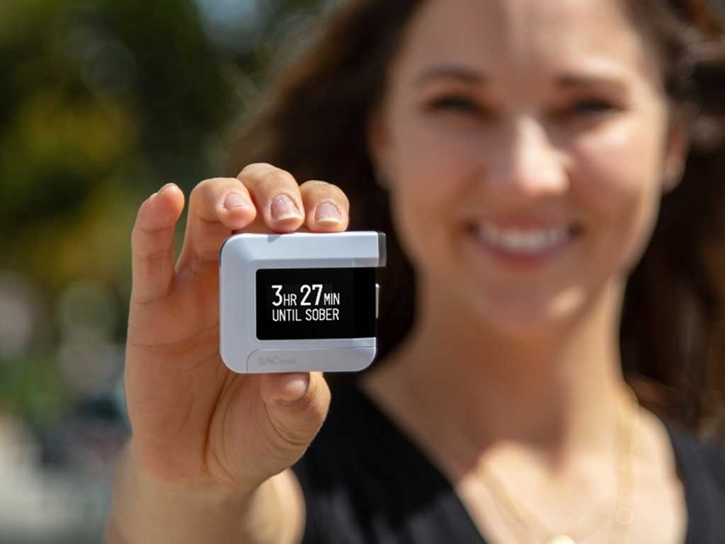 A woman showing the results on her BACtrack C8