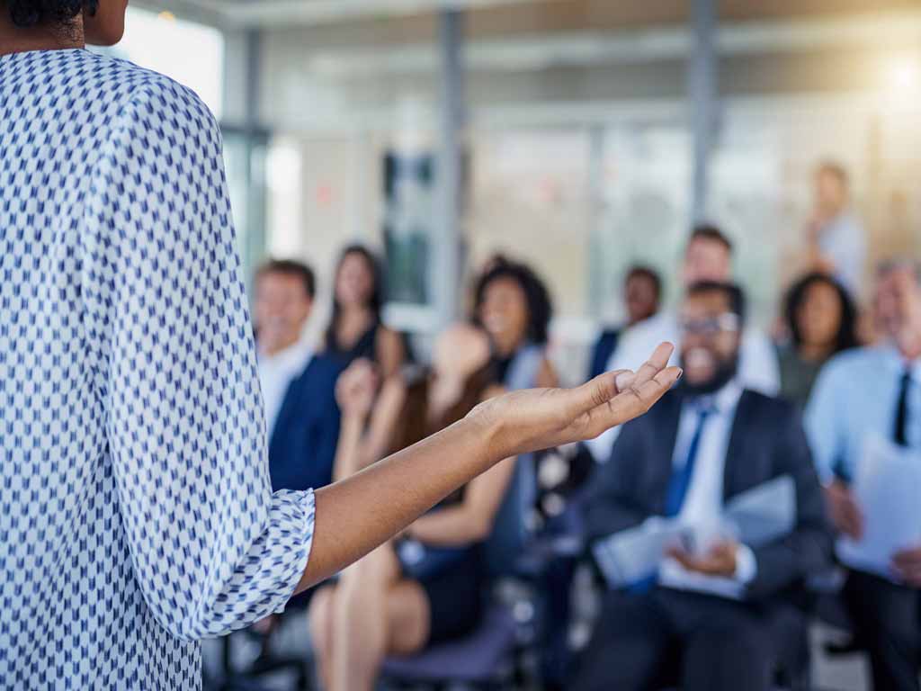 A woman giving a presentation to a group of workers