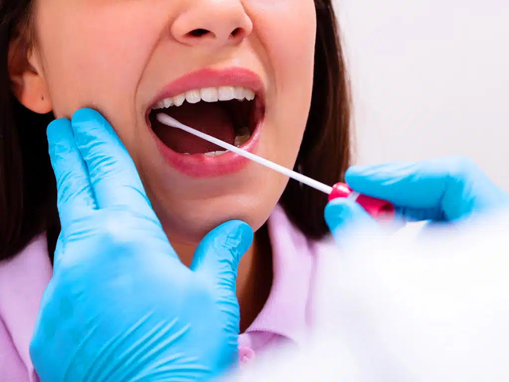 A trained collector gathering saliva samples from a woman
