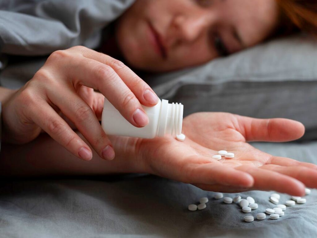 A woman taking pills while in bed