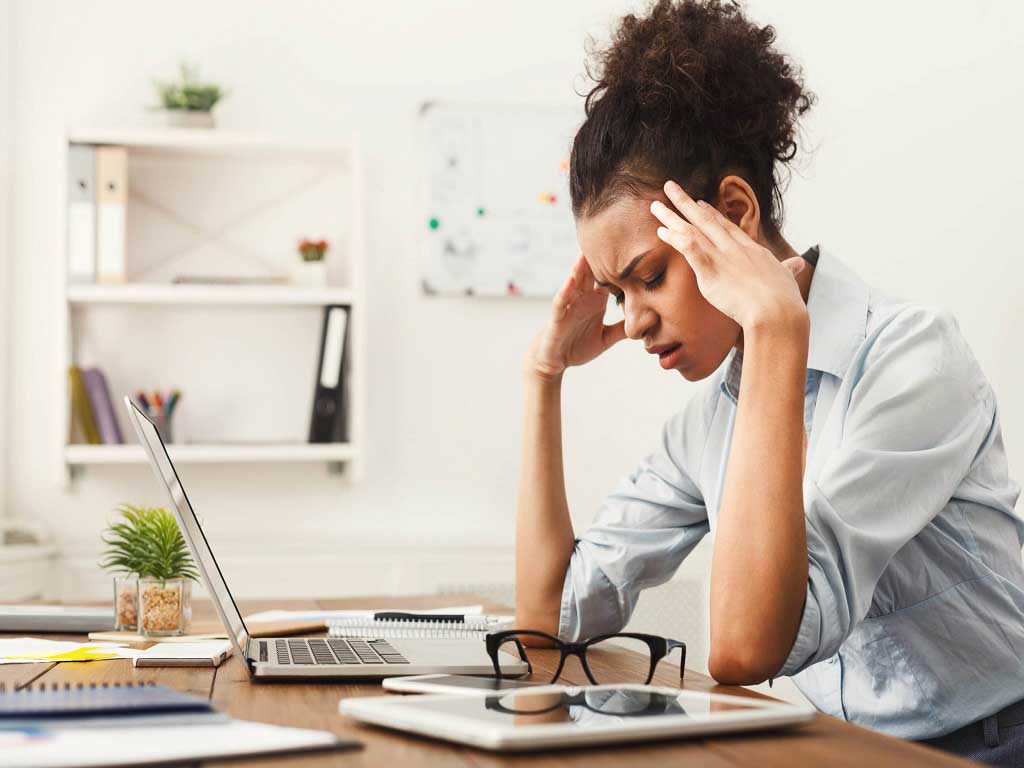A distressed-looking woman at her desk