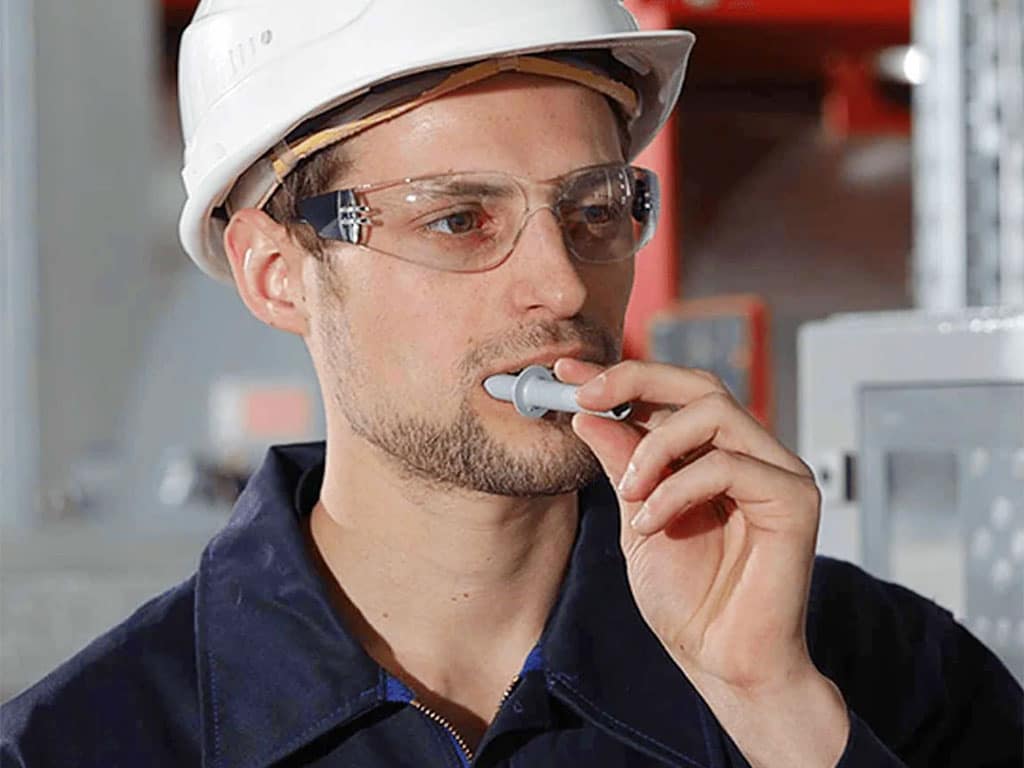 A male worker self-administering a saliva drug test