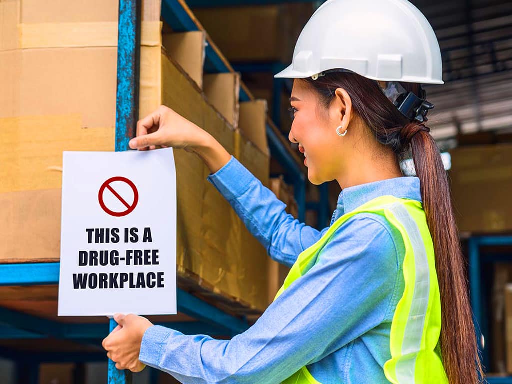 A female engineer posting a drug-free workplace sign