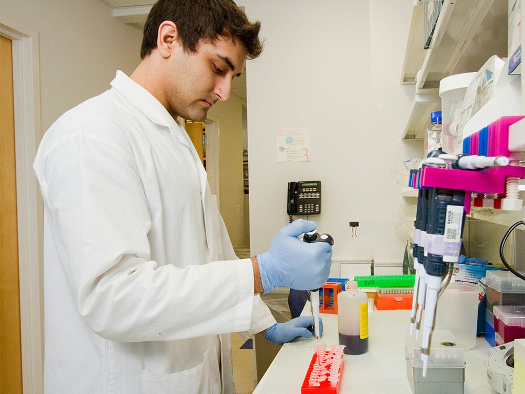A male technician conducting tests at a lab